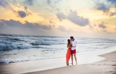 Young couple kissing on beach at sunset, Hikkaduwa, Southern, Sri Lanka